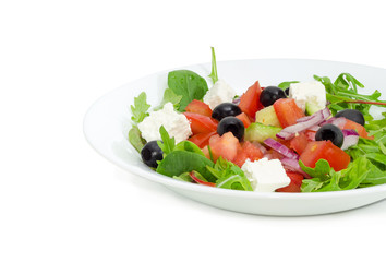 Greek salad in a white dish on a light background