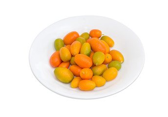 Kumquats on white dish on a light background