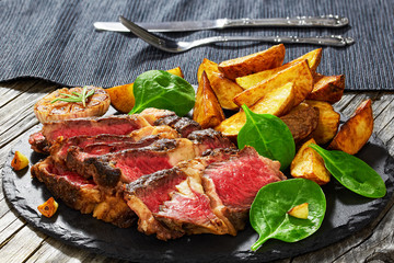 Juicy rib eye beef steak with fried potato wedges