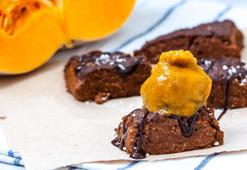 Pumpkin vegan brownie with a scoop of pumpkin ice cream and chocolate. Love for a healthy desserts concept.
