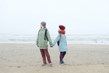 young couple walking on a winter beach