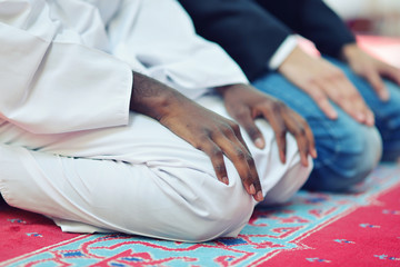 Two religious muslim man praying together inside the mosque