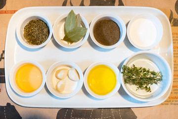Top view on various condiments and herbs and oils on containers