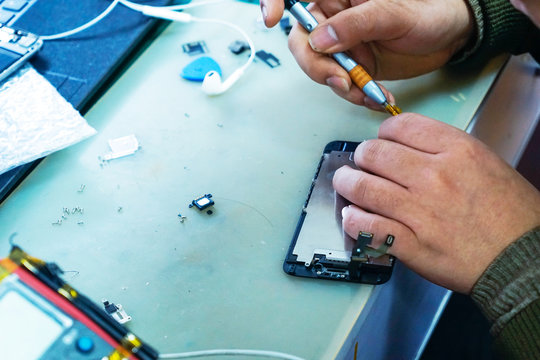 man technician repairing mobile phone