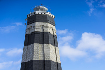 Vintage monochrome lighthouse on the sea under sky and clouds