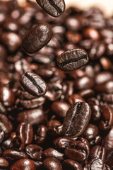 Fototapeta premium Dark coffee beans falling on the table