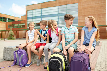 group of happy elementary school students talking