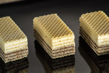 Waffles with chocolate on black glossy plate