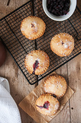 Blueberry hand pies sprinkled with sugar on wooden table