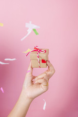 Obraz na płótnie Canvas Women hand holding gift box on pink background.