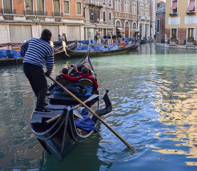 Fototapeta na wymiar tourists in a gondola in a canal in Venice