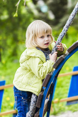 Happy little girl playng on outdoor playground