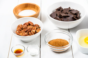 Pecan Nuts, Dark Chocolate Pieces, Sugar And Egg Yolk On Kitchen Table