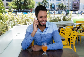 Fashionable caucasian man speaking at phone in restaurant