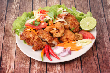 Spicy deep-fried chicken salad with roll green mango .