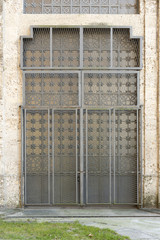 grated decorated door at historical power house at Trezzo over Adda