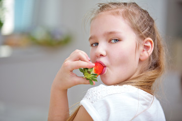 Mädchen beim Erdbeere essen in Küche