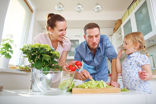 Familie in der Küche mit Salat