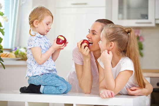 Mutter und Kinder essen Apfel zusammen