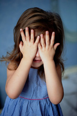 Fototapeta premium see no evil girl. Baby covers eyes with hands