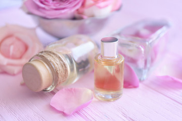 Obraz na płótnie Canvas Essential oils with flower petals on wooden background