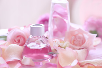 Obraz na płótnie Canvas Essential oil with rose petals on table