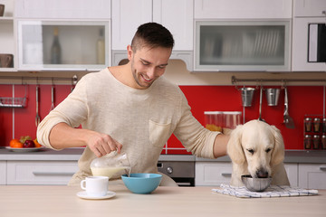 Man and  dog enjoying breakfast at the kitchen