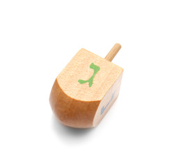 Wooden dreidel for Hanukkah on white background