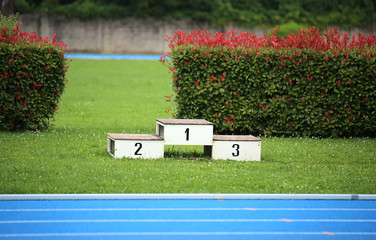 podium of an athletics stadium with numbers one two three