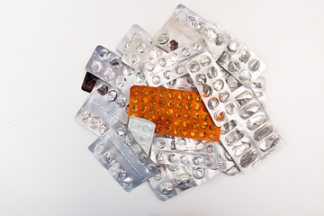 Heap of medicine tablets and pills in blisters on white backgrou