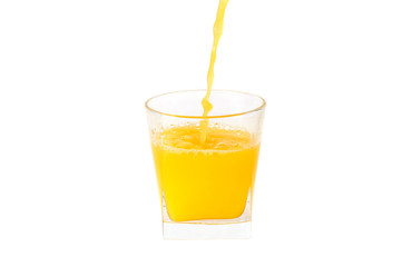 The juice is pouring into a glass. Isolated on white.