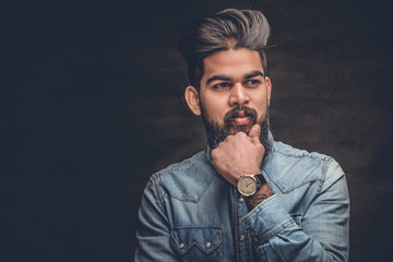  Indian man in a blue shirt over grey background.