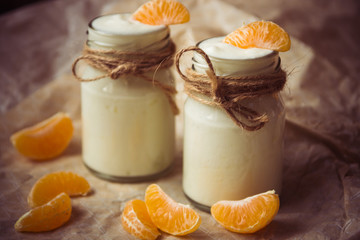 Organic yougurt with fresh tangerine in glass jars