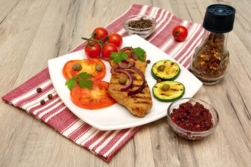 appetizing piece of roasted meat on the grill with vegetables an