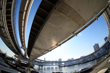 Obraz premium 青空と芝浦ふ頭の橋 レーンボーブリッジに昇って行くサークル橋が迫力満点だ。