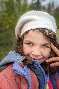 Outdoor portrait of cute smiling young girl with gap teeth. 
