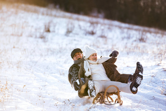 Beautiful Senior Couple On Sledge Having Fun, Winter Day.