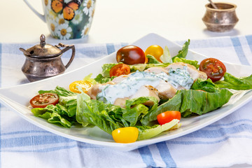Salad with chicken breast, yogurt dressing and mixed tomatoes.
