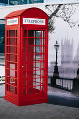 The London red public callbox stands on the sidewalk