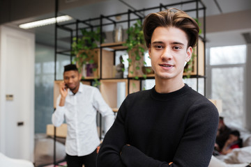 Photo of two young handsome students in library