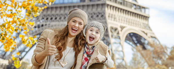 Fototapeta premium mother and child travellers in Paris, France showing thumbs up