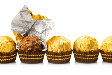 Group of candy in gold wrappers, isolated on white background