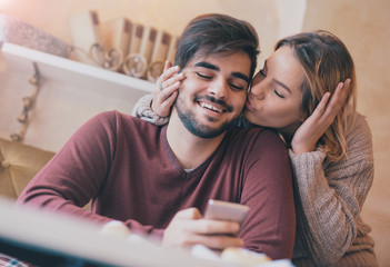 Young couple having fun with smartphone in the cafe. Love, datin