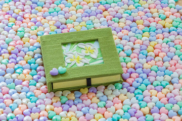 Green notebook and flower on cover with colorful pastel heart sh