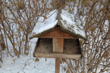 Obraz na płótnie Canvas Birdhouse-feeder in the snowbound winter city park