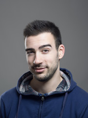 Portrait of funny young handsome expressive man winking at camera