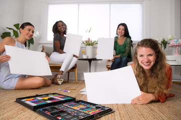 Diverse group of women bonding at house social art craft night together relaxing and creating