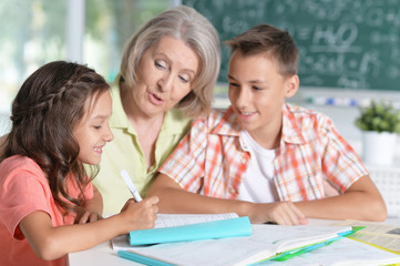 Fototapeta premium granny with grandchildren doing homework