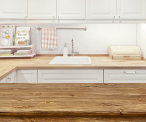 Blurred kitchen interior with wooden dinning table in front