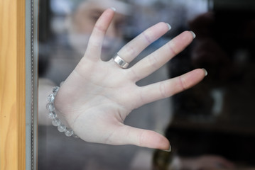 Woman hand behind glass